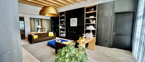 Un salon moderne avec un canapé, une table basse et une grande plante en pot.
