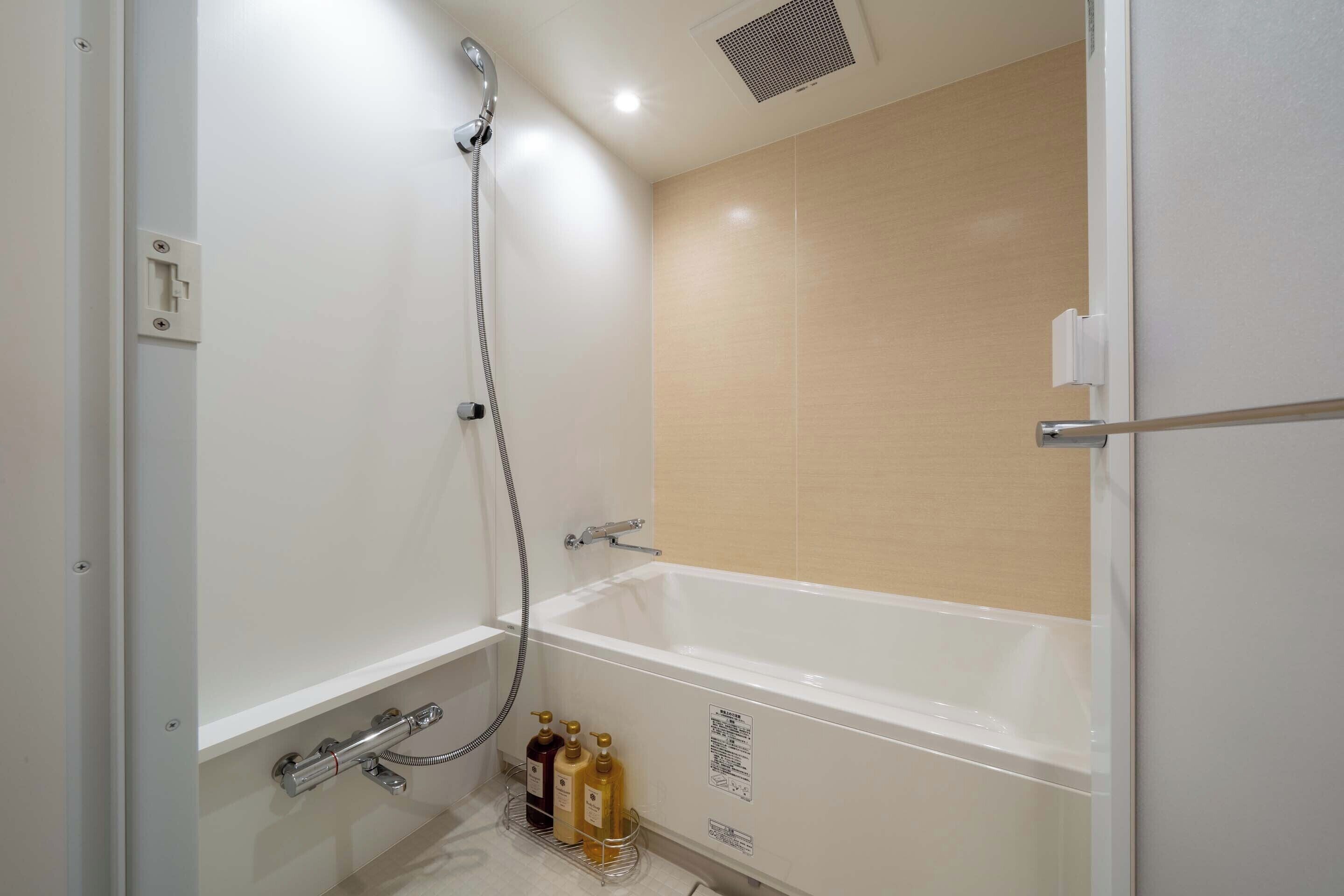 Un baño moderno con bañera, ducha e inodoro.