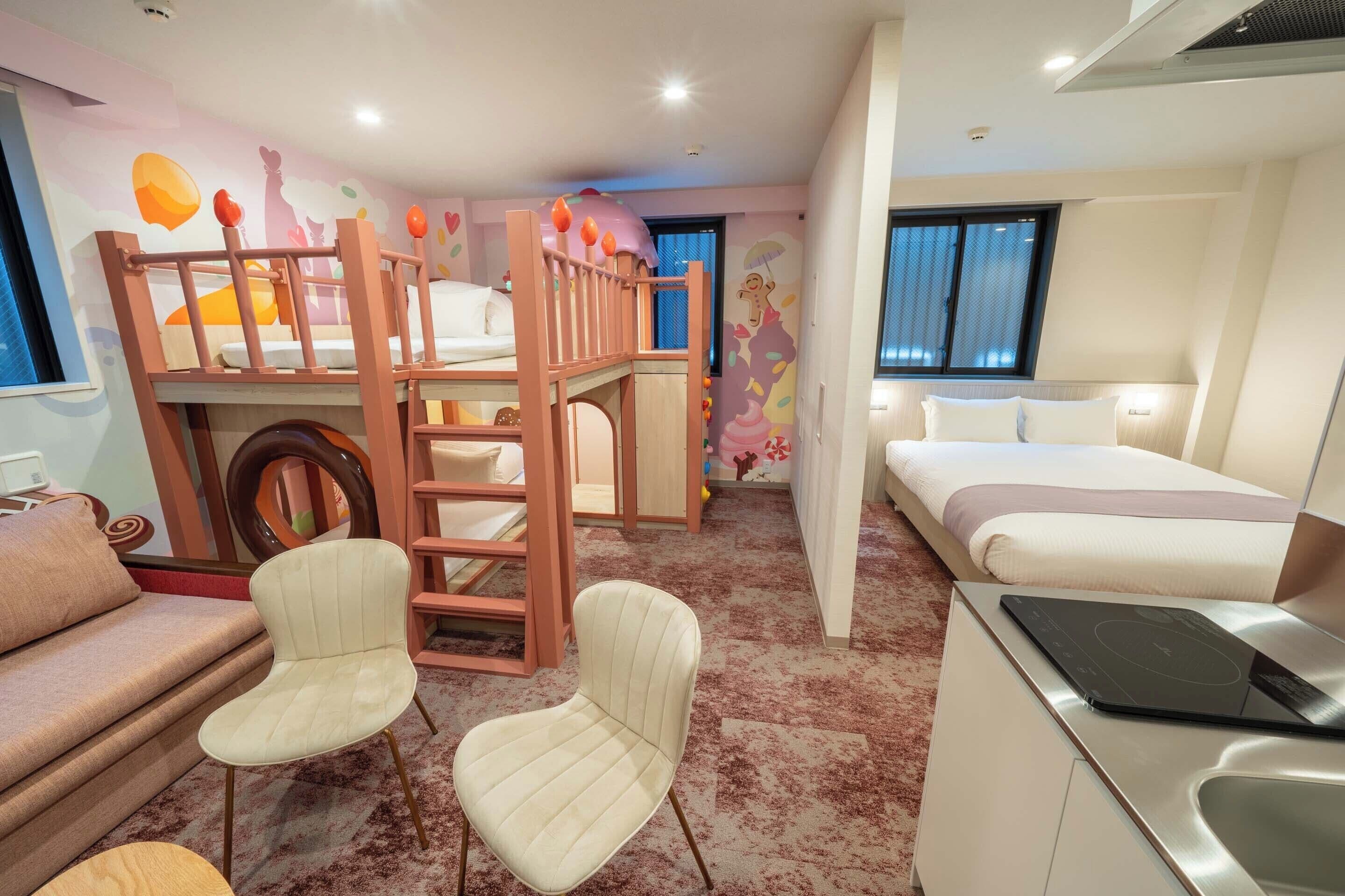 A children's room with bunk beds, a sofa, a chair, a desk with a laptop, and a bed.