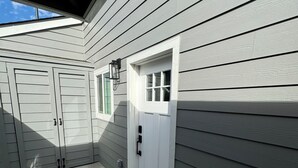 A residential building with a garage door, a front door, and a small window.