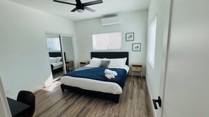 A bedroom with a bed, bedside tables, a ceiling fan, and a window with blinds.