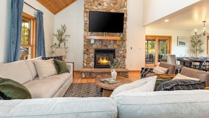 A cozy living room with a stone fireplace, a flat-screen TV, and comfortable seating. - Galena Getaway: Sauna, Hot Tub, Fire Pit, and Arcade Fun Awaits! (Galena)