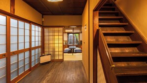 A traditional Japanese interior with a wooden staircase, tatami mat flooring, and sliding doors. -  Nijo-Ouan (Kyoto)