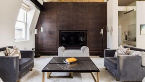Una sala de estar moderna con una pared de acento en madera oscura, una chimenea y dos sofás.