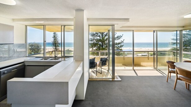 Una cocina moderna con un ventanal y vista a la playa.
