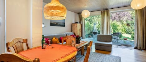 En matplats med ett träbord, stolar och en hängande lampa.