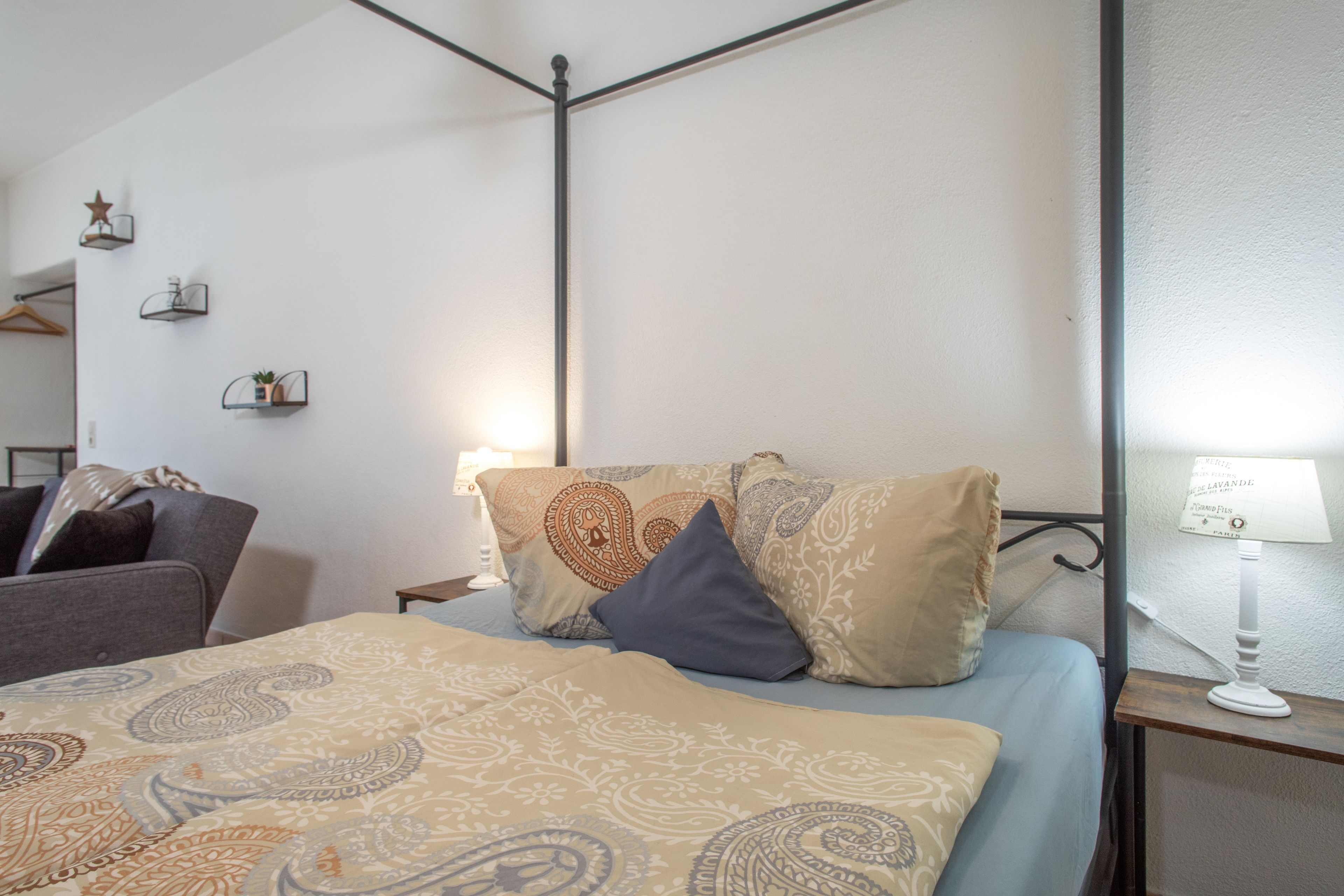 Ein Schlafzimmer mit einem Bett, einem Nachttisch, einer Lampe und einer Pendelleuchte.