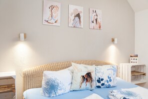 A bedroom with a bed, pillows, a nightstand, and wall-mounted artwork. - 'Room 4', cozy double room with large bed (Ravensburg)