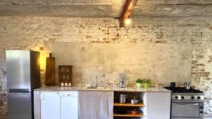 Eine kleine Küche mit Kühlschrank, Geschirrspüler, Herd und einer Spüle.