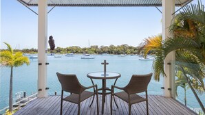 A covered outdoor seating area with a view of a marina. - Riverside Elegance on Noosa Parade (Noosa)