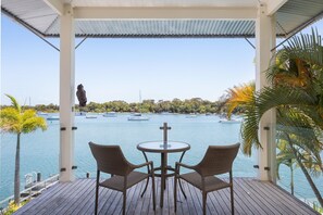 A covered outdoor seating area with a view of a marina. - Riverside Elegance on Noosa Parade (Noosa)