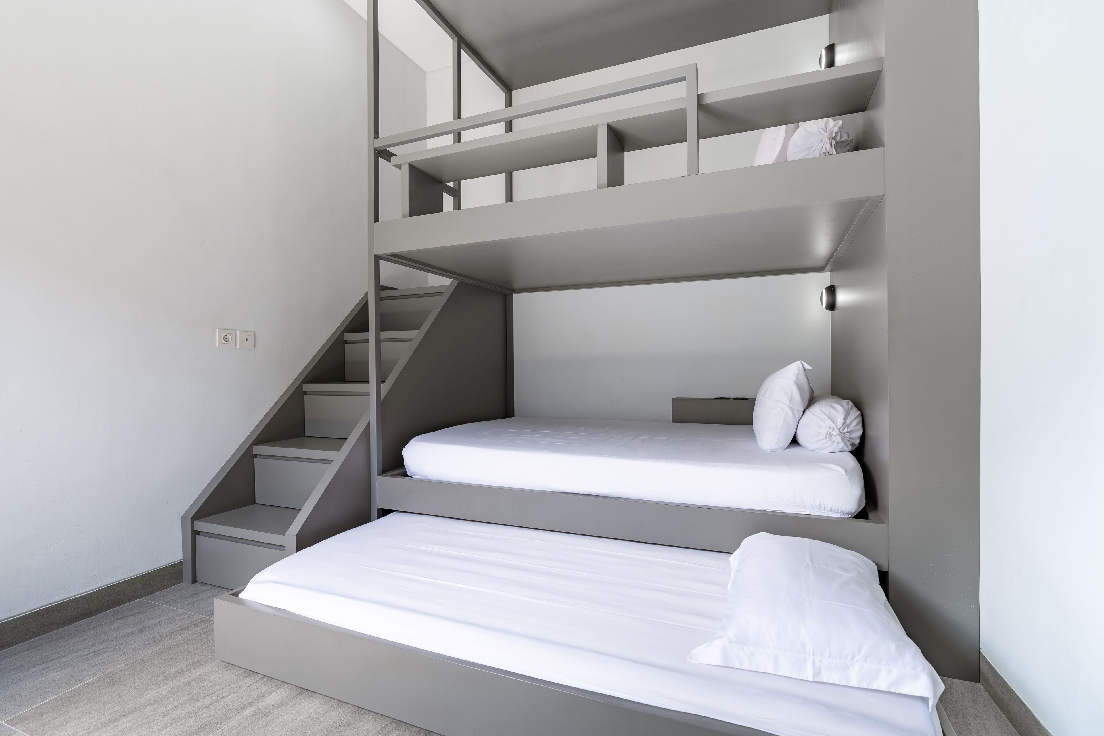 Et moderne, flerniveaubedrum med indbyggede trapper og et minimalistisk design.