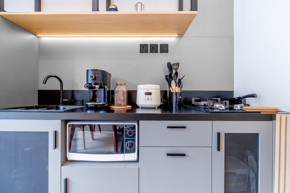 A compact kitchen with a microwave, coffee maker, and toaster. - Feels Like Home Villa (Blahbatuh)