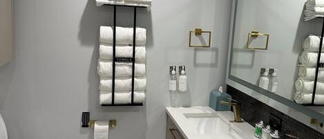 A modern bathroom with a toilet, bidet, and a large mirror.