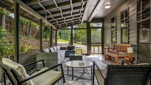 A covered outdoor seating area with wicker furniture, a round table, and a bench. - *Central! Game Room! Hot Tub!* (Pigeon Forge)