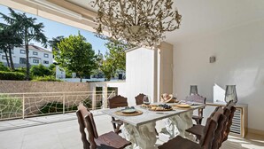 A dining area with a marble table, wooden chairs, and a chandelier. - Villa Rosa Estoril Retreat by Portugal Portfolio (Estoril)