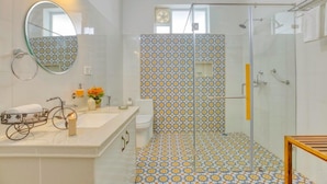 Ein Badezimmer mit Dusche, Waschbecken, Spiegel und Toilette.