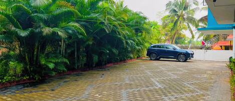A paved driveway leading to a building with a blue and pink exterior.