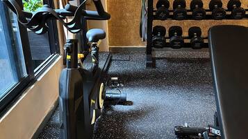 A gym with exercise equipment, a kettlebell rack, and a window with a view.