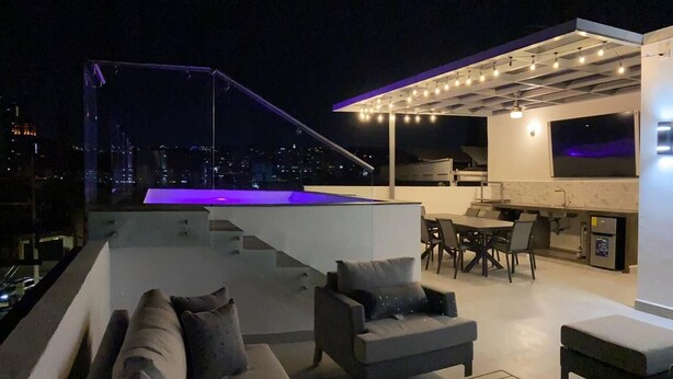 Terraço no telhado com piscina, área de estar ao ar livre e bar.