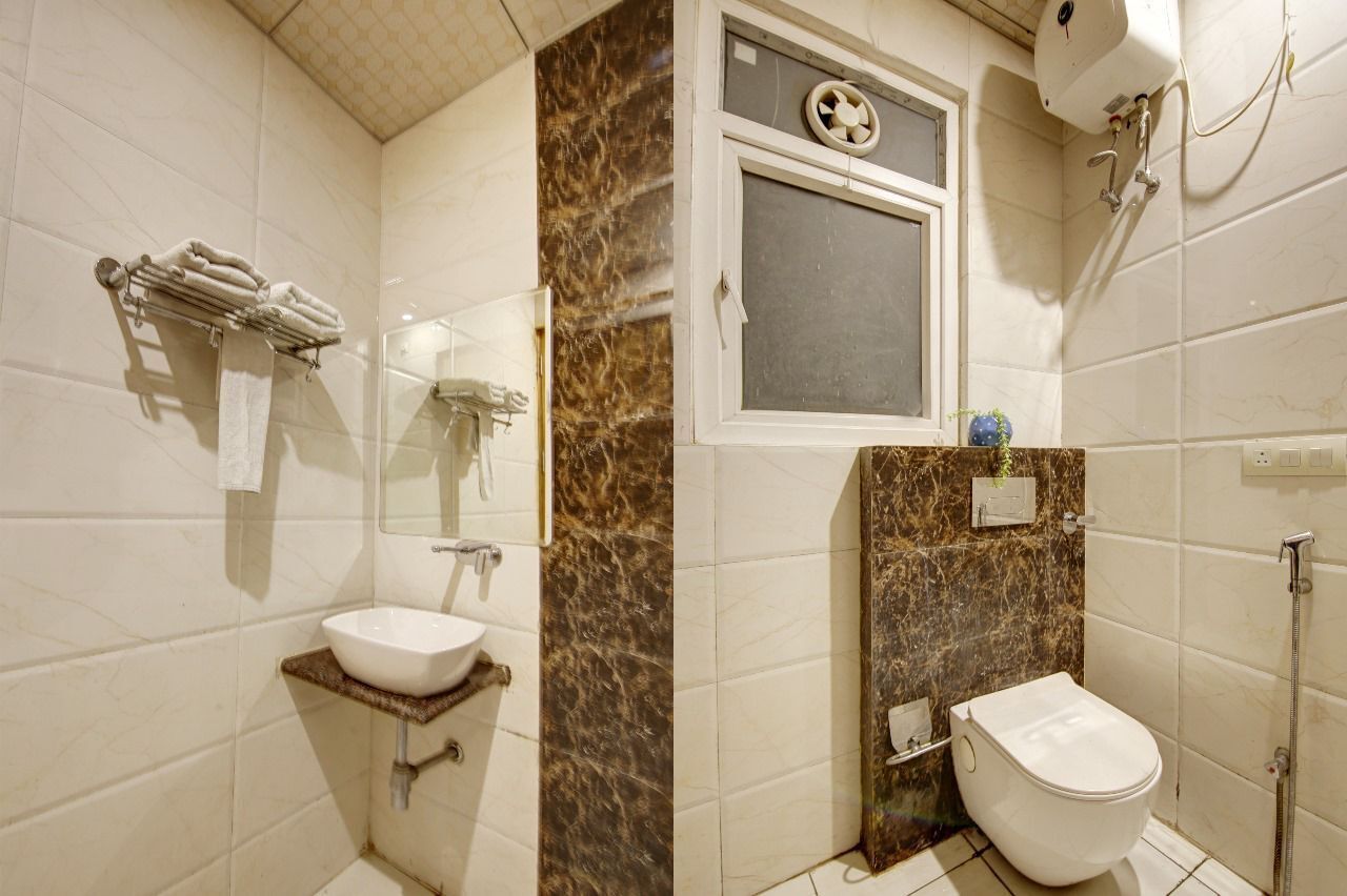 A bathroom with a white sink, a toilet, and a shower area.