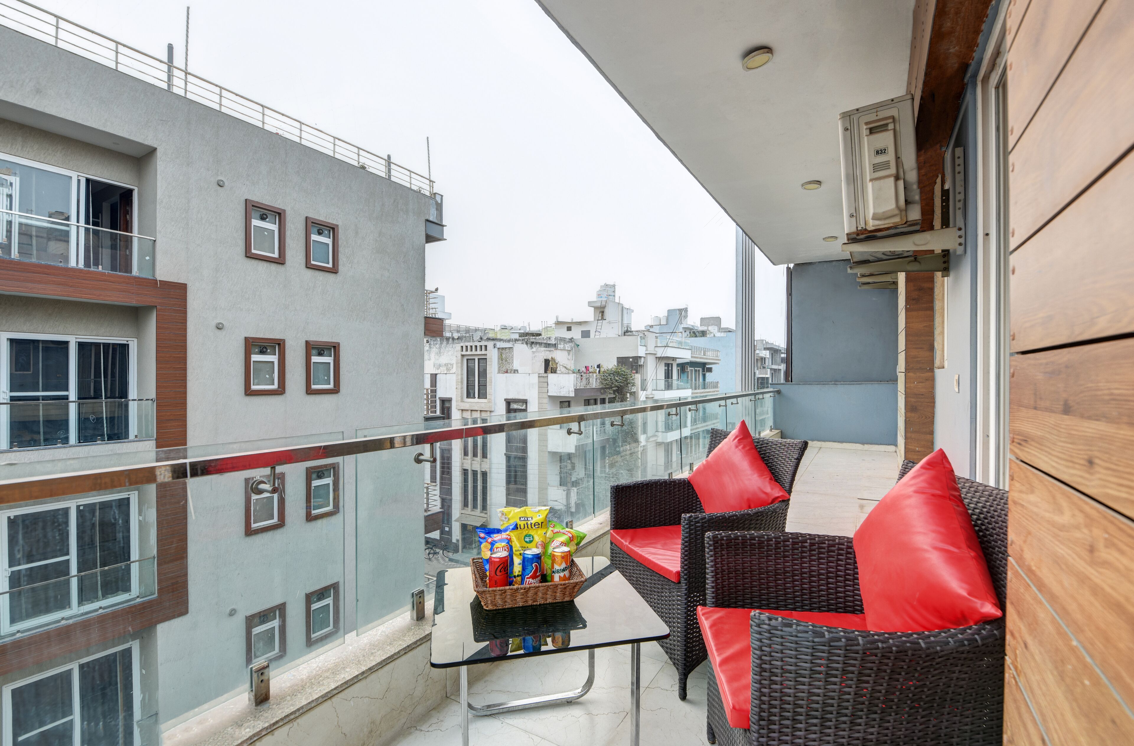 Un balcon agrémenté de meubles en osier et d’une table où sont disposés des en-cas.