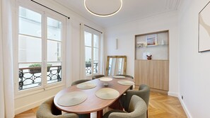 Enjoy meals with family and friends in this dining area, featuring a long table and comfortable seating for four.