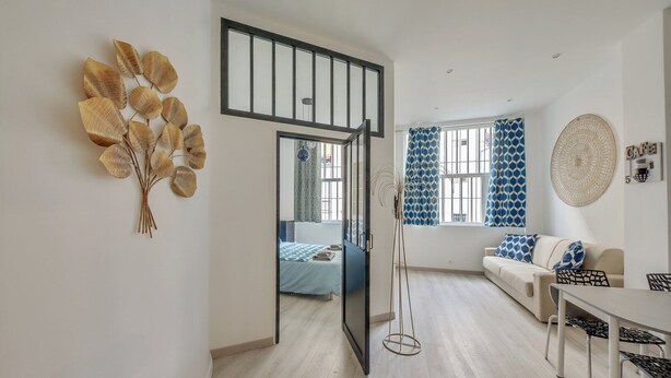 Un salon moderne avec un canapé, une table à manger et un escalier menant à une autre pièce.