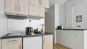 Una cocina moderna con armarios de madera clara, un lavavajillas Bosch y una cafetera sobre la encimera.