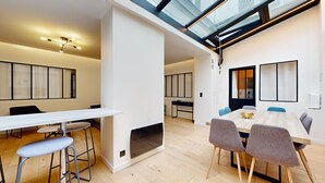 A modern interior with a dining area, a kitchen, and a living space. - TBS 151- Lovely suite near Place de la République (Paris)