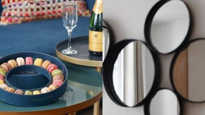 A room with a bed, a round table with a blue macaron tray, a champagne bottle, and a glass. - TheBlueStay 31 – Modern Apartment – Paris 13 (Paris)