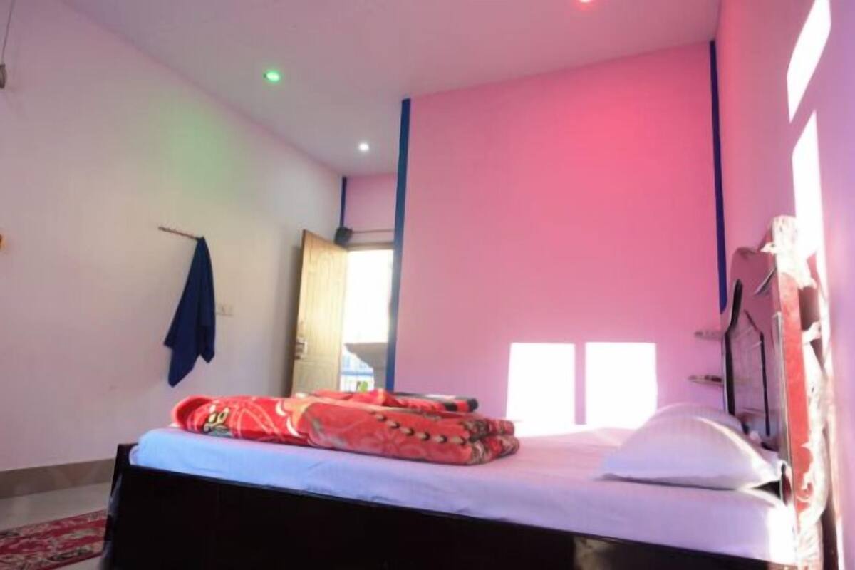 A bedroom with a bed, a window, and a door.