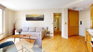 Un salon moderne avec un canapé, une table basse et un tableau accroché au mur.