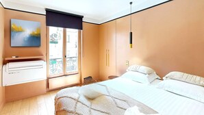 Une chambre moderne avec un lit, un bureau et une fenêtre donnant sur la ville.