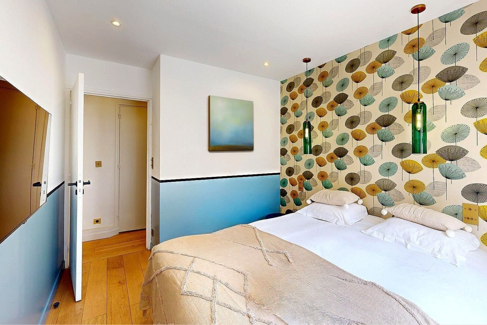 Een slaapkamer met een bed, een deur en een muur met behang.