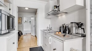 Una cocina moderna con microondas, cafetera y hervidor.