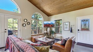 A spacious living room with a high ceiling, large windows, and a cozy seating area. - Potter's Peak (Cascade)