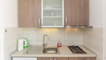 Coffee/tea maker, fridge, stovetop, dining table