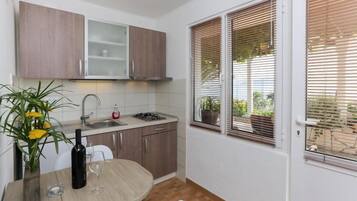 Coffee/tea maker, fridge, stovetop, dining table