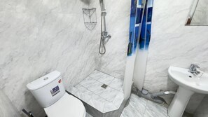 A bathroom with a toilet, shower, and sink. - Parvona Hostel (Tashkent)