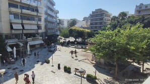 An urban square with buildings, trees, and outdoor seating areas.