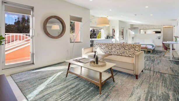 Un salón moderno con un sofá, una mesa de centro y vistas al balcón exterior.