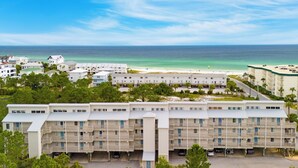 Un hôtel situé en bord de mer, avec plusieurs étages, des balcons et un espace de stationnement.