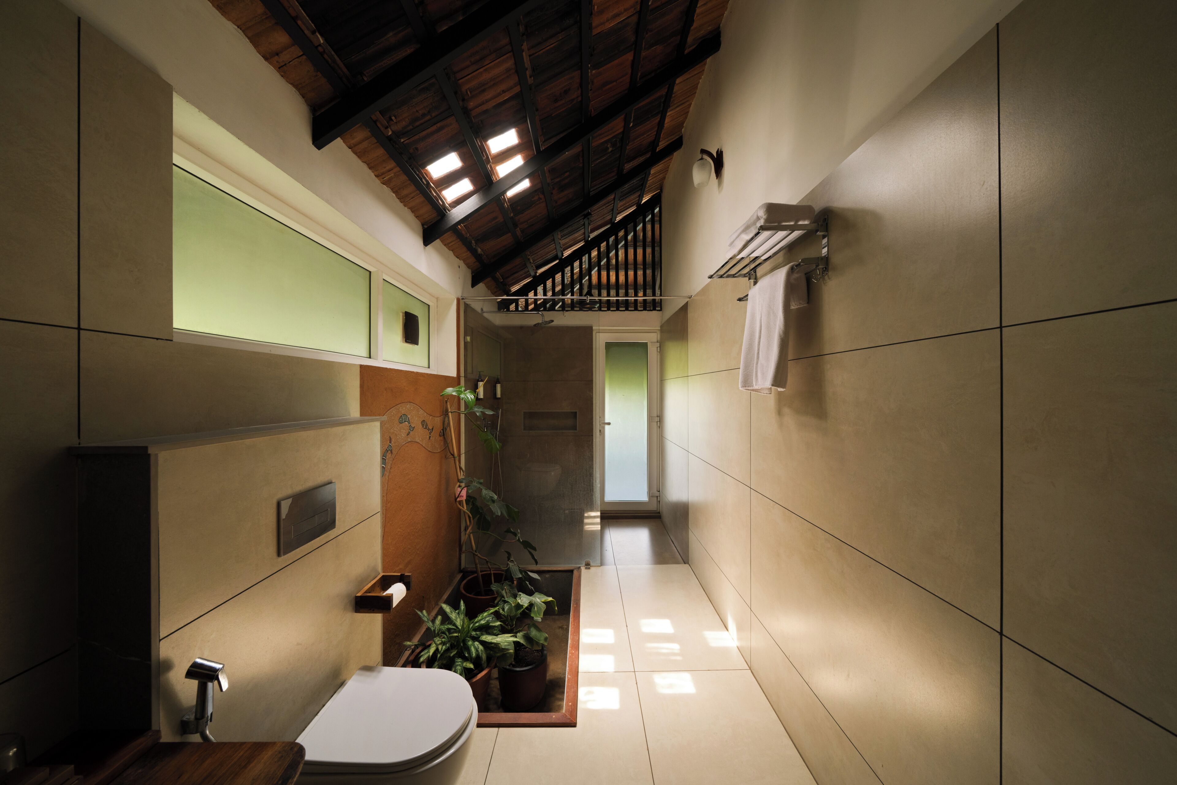 A narrow hallway with a toilet, a sink, and a shower area.