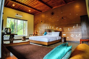 Un dormitorio con una cama grande, techo de madera, ventana con vistas a la vegetación y pared con un mural.