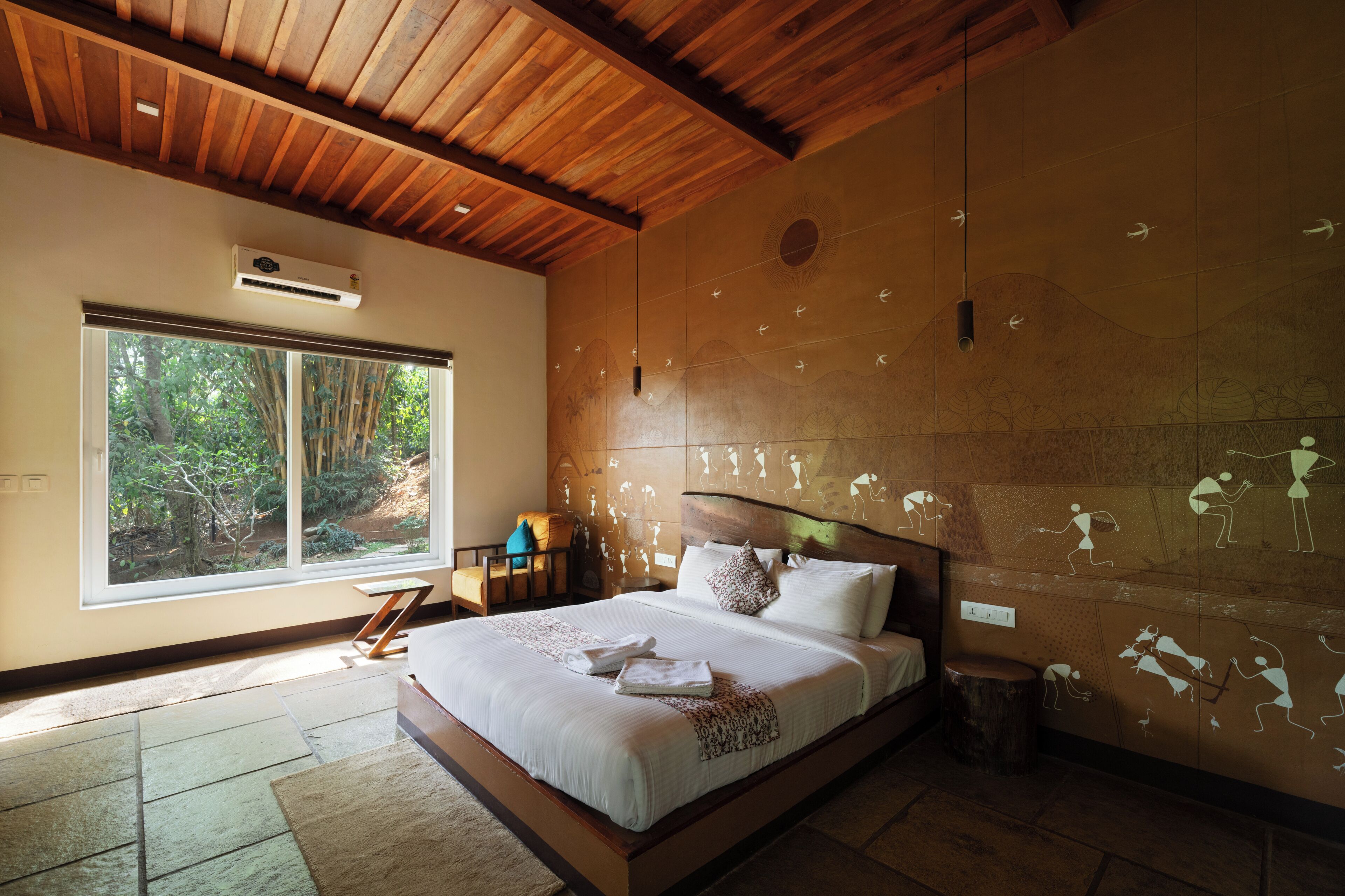Um quarto com uma cama grande, uma janela com vista para árvores e teto de madeira.