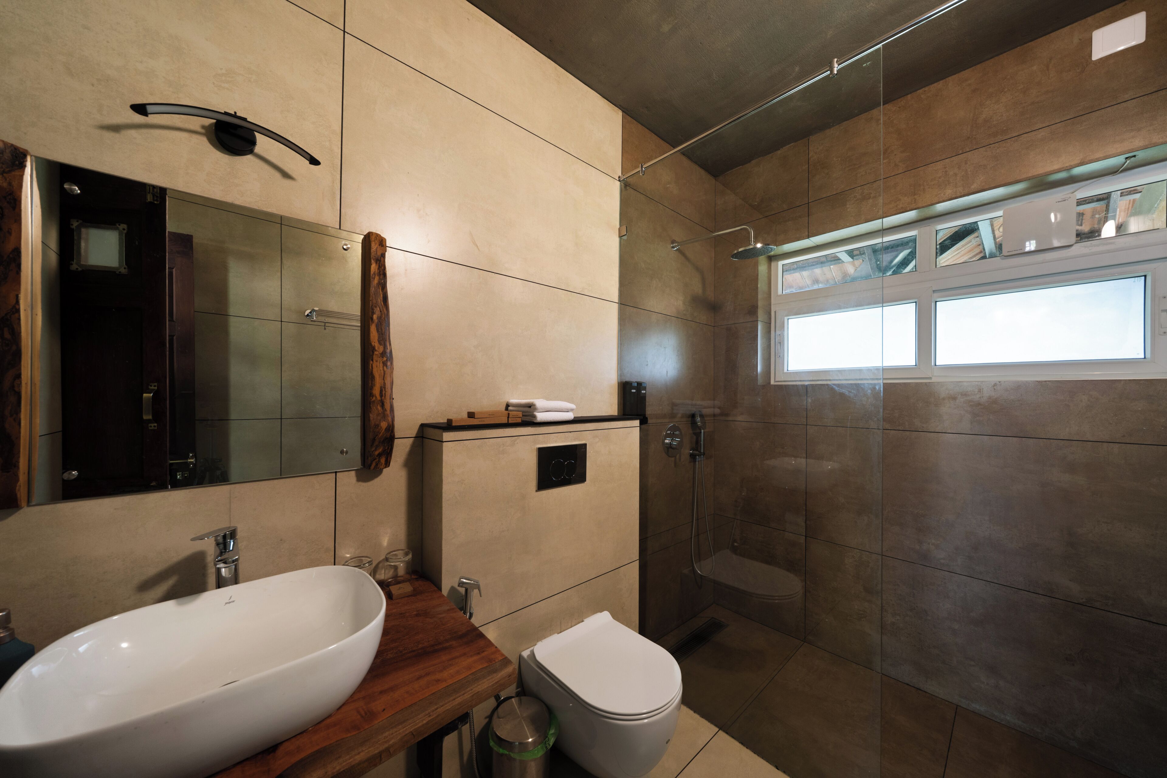Un baño moderno con un espejo grande, dos lavabos, un inodoro y una ducha.