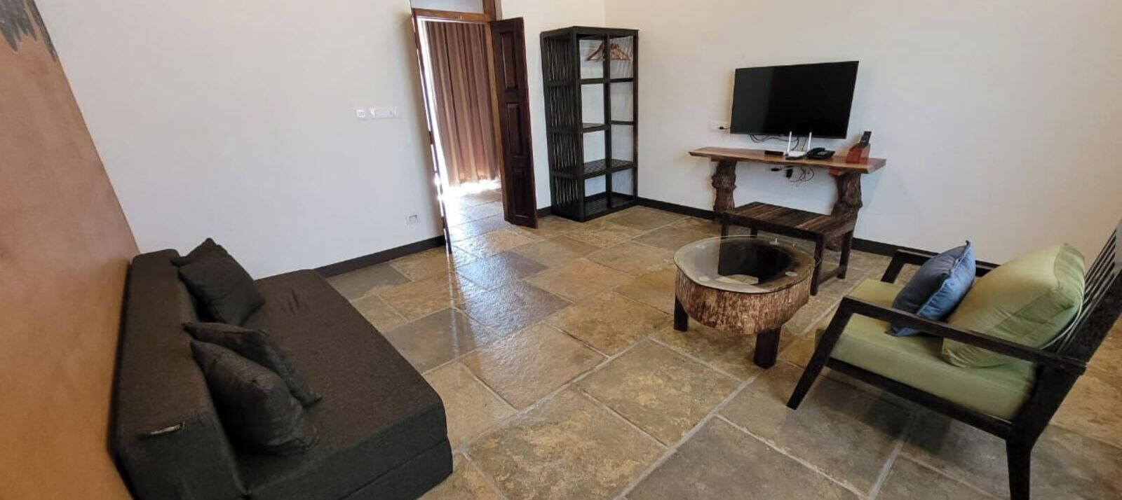 A living room with a sofa, a coffee table, a TV, and a bookshelf.
