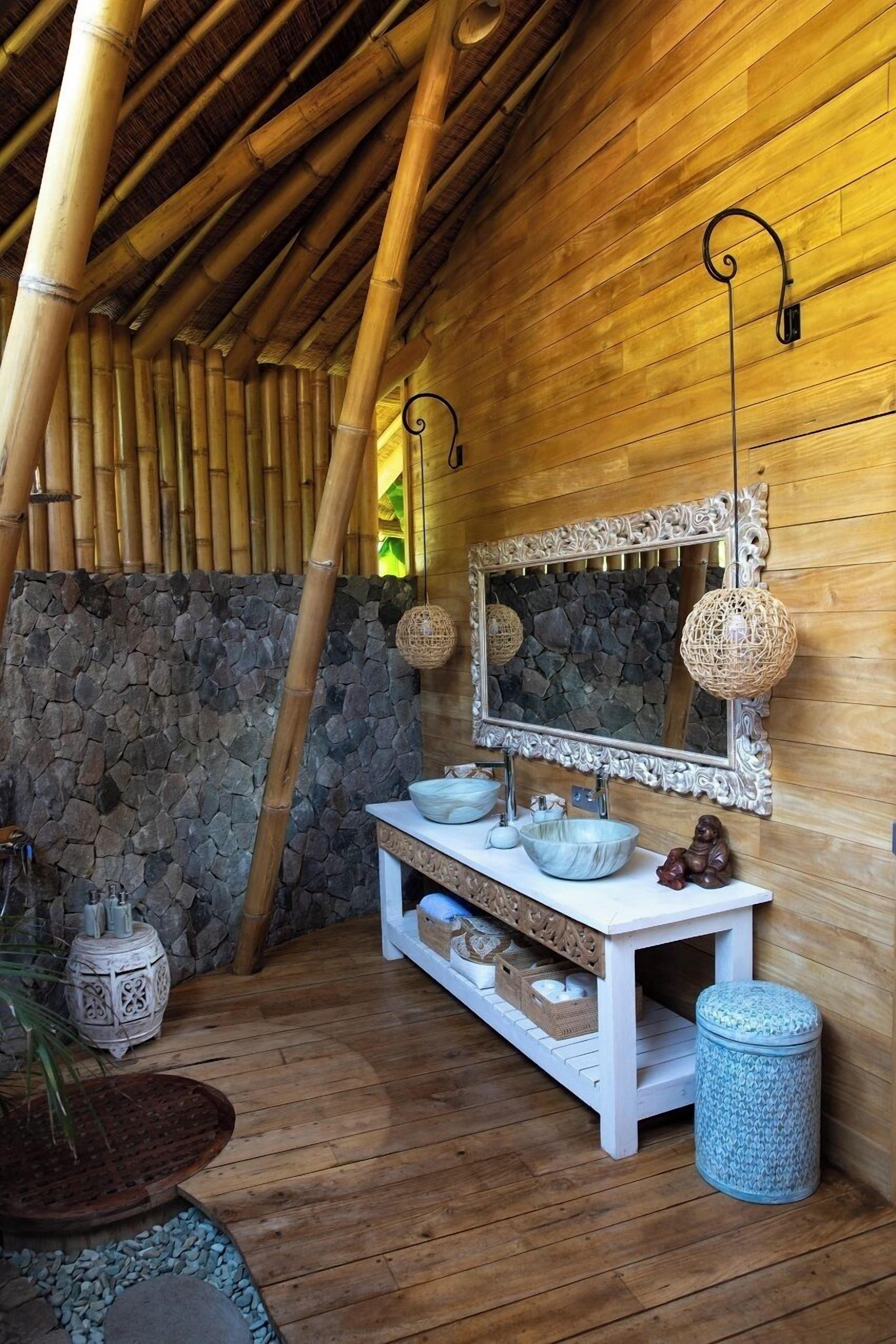 A wooden room with a stone wall, a white vanity with a mirror, and a hanging light fixture.