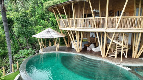 A bamboo structure with a pool, surrounded by lush greenery. - Villas Bukit Lipah (Karangasem)